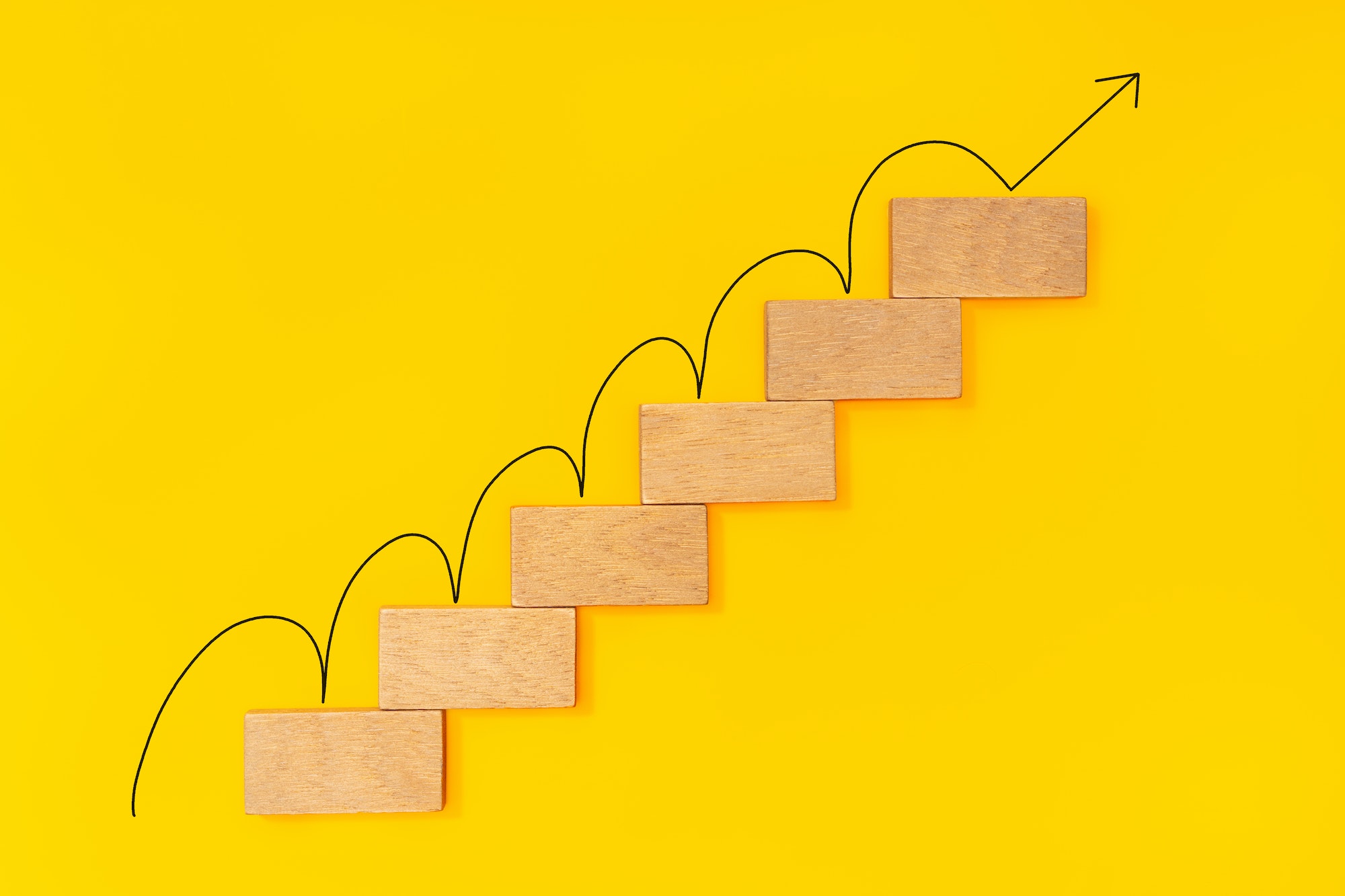 Rising arrow on wooden staircase